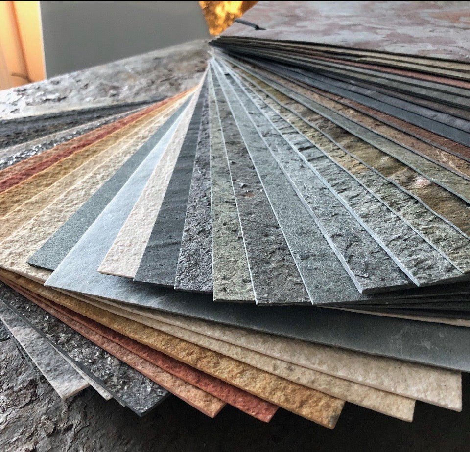 A selection of thin textured stone samples arranged in multiple colours and finishes
