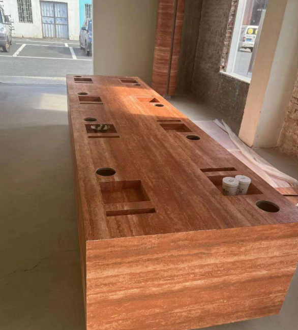 flexible stone wrapped on table with multiple holes and recesses in an indoor setting 